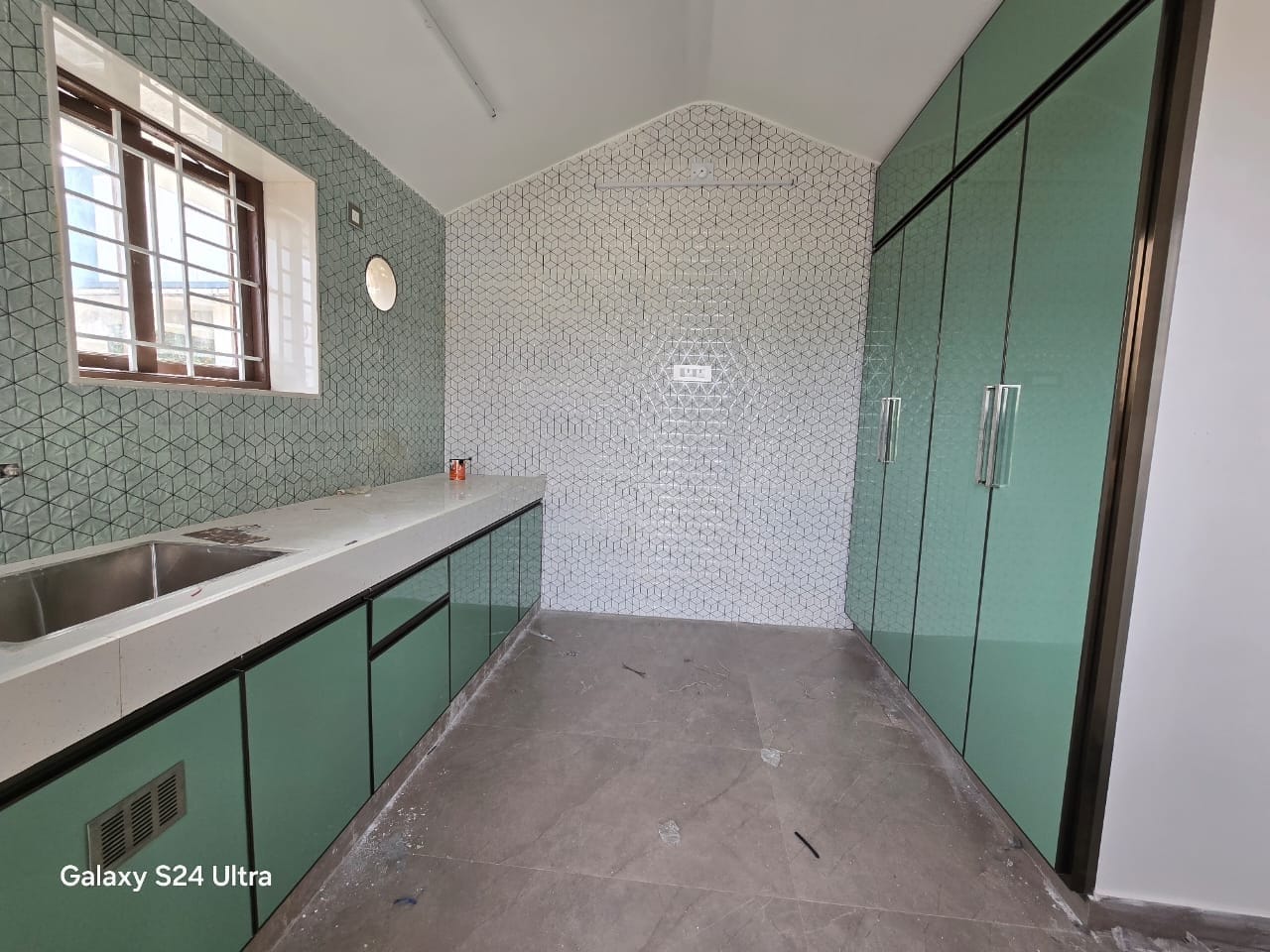 Green modular kitchen with patterned wall tiles